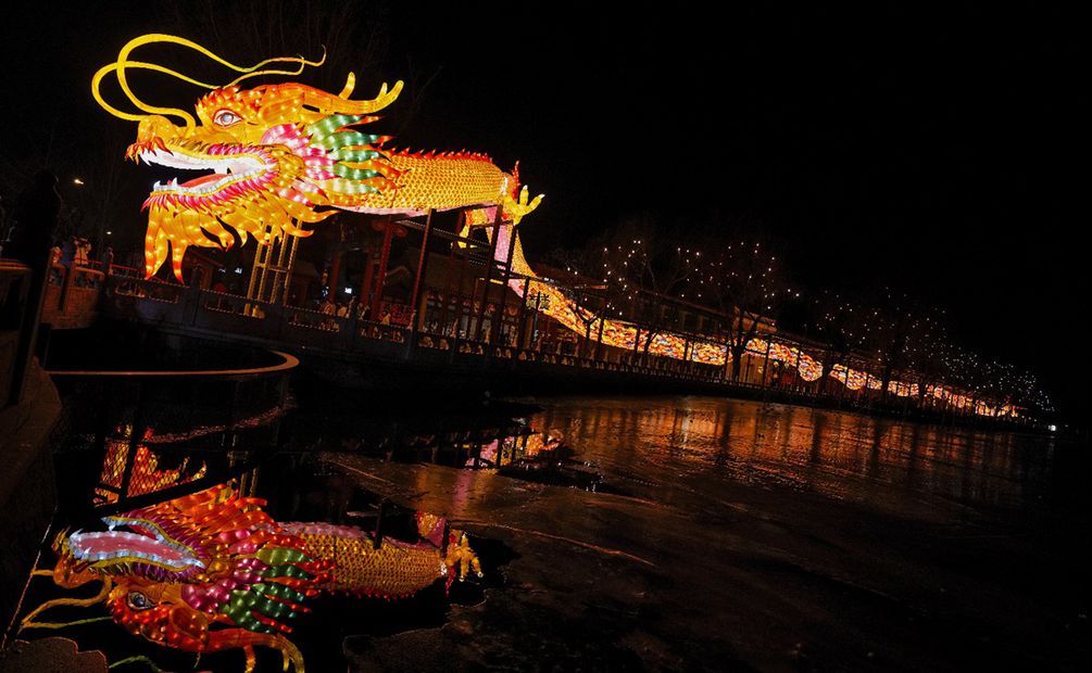 Visitantes pasan por debajo de una linterna enorme con forma de dragón, en el lago Houhai, en Beijing. Foto: AP