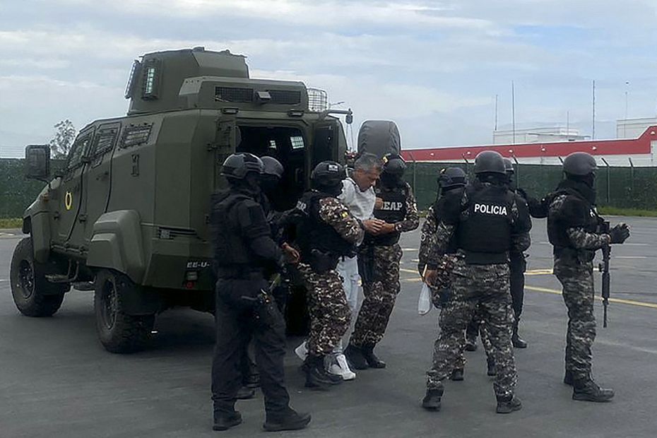 Jorge Glas (C) escoltado por miembros de la policía antes de su traslado a la prisión de máxima seguridad La Roca en Guayaquil en el Aeropuerto Internacional Mariscal Sucre. Foto: Policía Ecuatoriana / AFP