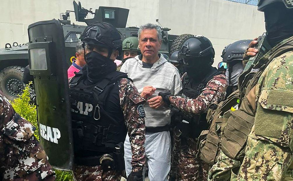 Esta fotografía publicada por la policía ecuatoriana muestra al ex vicepresidente ecuatoriano Jorge Glas (C) escoltado por miembros de la policía antes de su traslado a la prisión de máxima seguridad La Roca en Guayaquil en el Aeropuerto Internacional Mariscal Sucre en Quito el 6 de abril. Foto: EFE