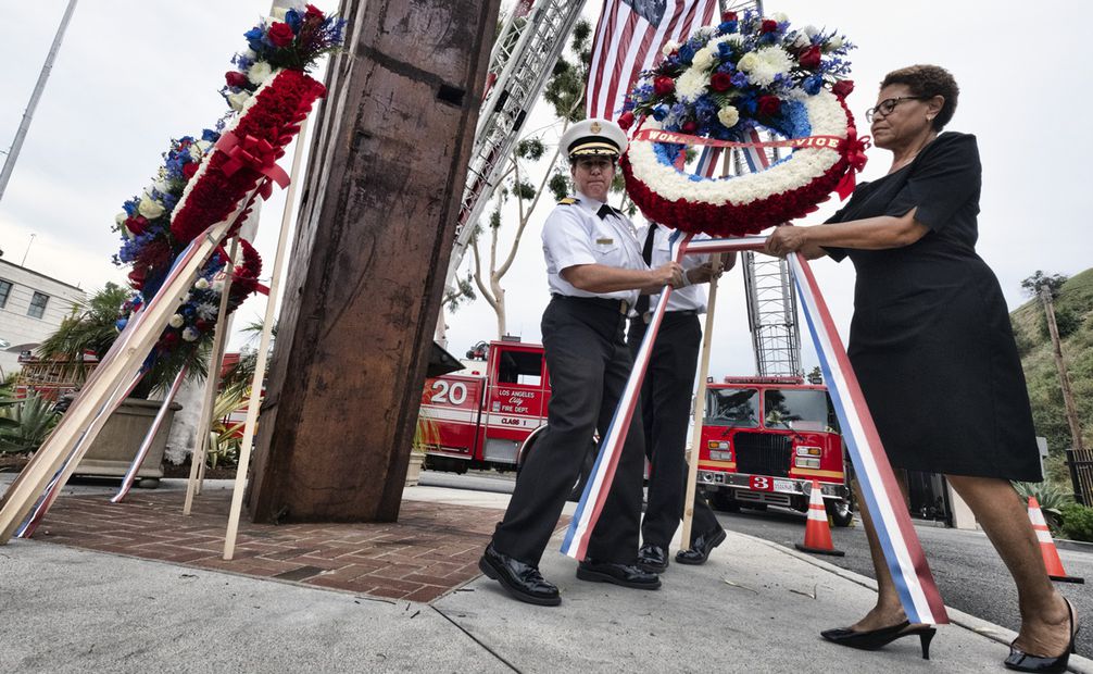 La alcaldesa de Los Ángeles, Karen Bass, a la derecha, acompañada por la jefa de bomberos de Los Ángeles, Kristin M. Crowley, colocando una corona de flores en la base de una sección de la torre sur del World Trade Center. Foto: AP