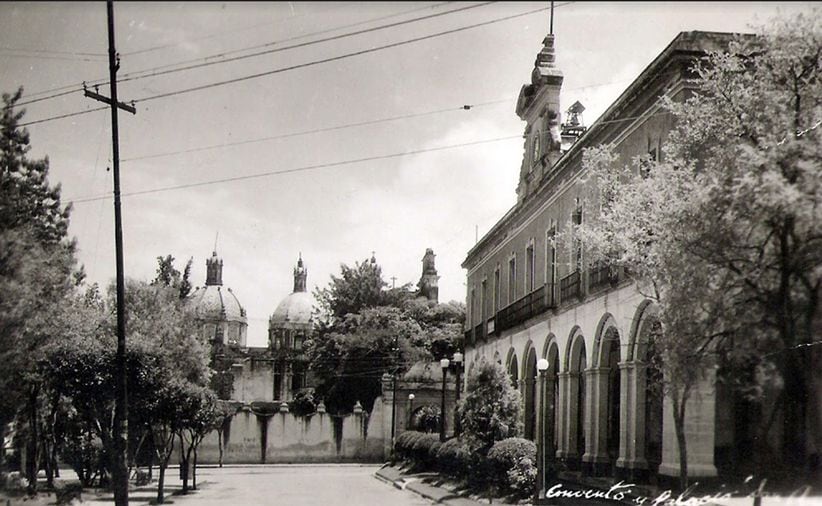 Las inmediaciones de la Plaza del Carmen con el antiguo Palacio Municipal de San Ángel del lado derecho, en los años veinte. El antiguo edificio fue construido en 1887 y se demolió en 1952 para ampliar la Calle del Ferrocarril del Valle, hoy Revolución; en su lugar se levantó otro edificio que hoy funciona como el Centro Cultural San Ángel. Al fondo se encuentran el convento y el templo de El Carmen. Imagen: Col. Villasana-Torres