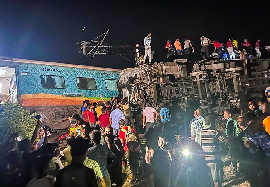 La gente inspecciona el sitio de los trenes de pasajeros que descarrilaron en el distrito de Balasore, en el estado de Orissa, en el este de India, el viernes 2 de junio de 2023. Foto: AP