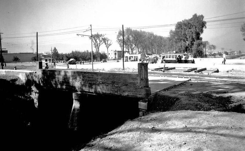 Vista del cruce de la Calzada de Tlalpan, el Río de la Piedad y la Calzada de los Cuartos o de la Ermita, hoy Obrero Mundial, viendo hacia la colonia Álamos, en la década de los cuarenta. Se distinguen los rieles del tranvía pegados a la acera oriente de la calzada.