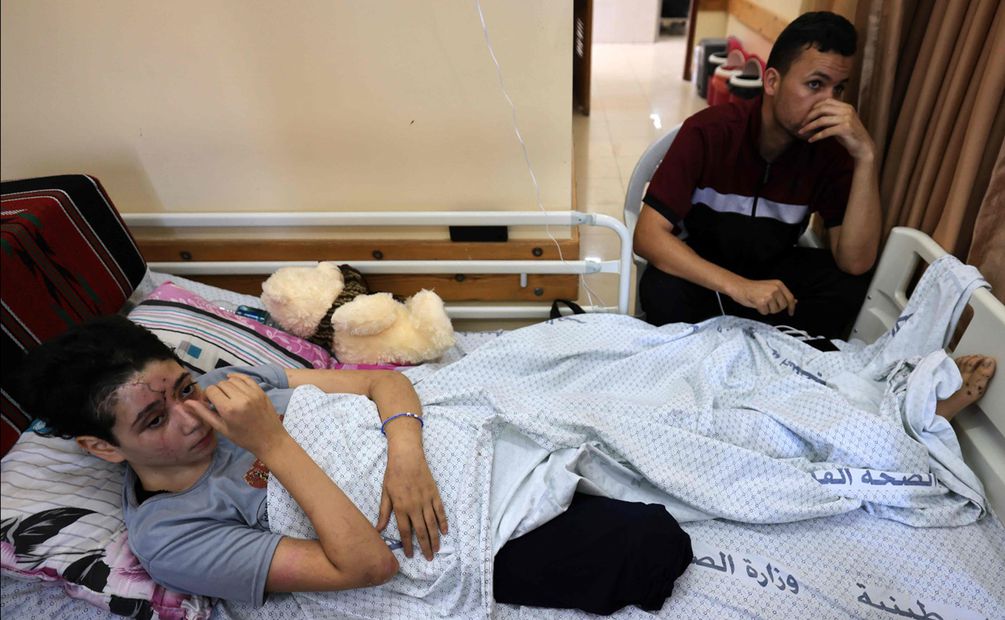 Lama y su hermana Sarah, de 15 años, reciben tratamiento en camas adyacentes después de un ataque el 12 de octubre que mató a Sama, la gemela de Sara, y a su hermano Yahya, de 12 años. Foto: AFP