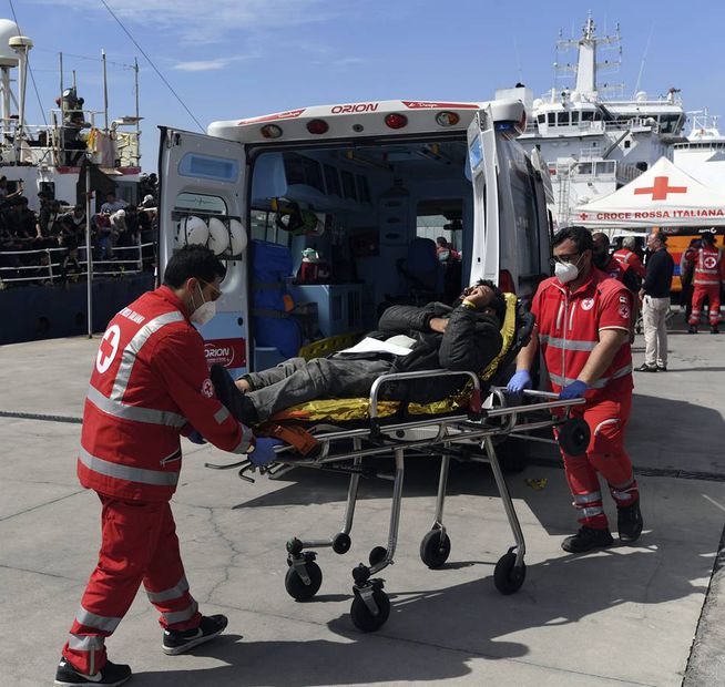 Paramédicos italianos atienden a uno de los migrantes que llegaron a la costa siciliana este miércoles. Foto: AP