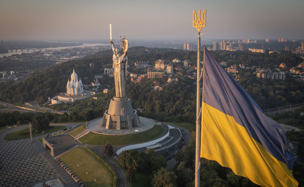 La bandera ucraniana ondea mientras trabajadores instalan el escudo en la estatua más alta del país, en Kiev. Foto: AP
