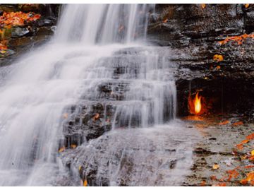 Learn about the phenomenon of fire flames behind the waterfall 
