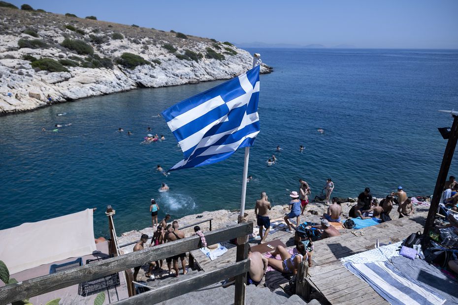 Bañistas, en las rocas junto al mar, en el suburbio de Vioulagmeni, al sureste de Atenas. En la isla de Rodas, los visitantes fueron evacuados. Foto: AP
