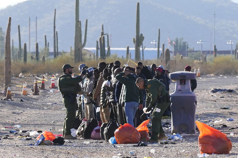 Personal de la Patrulla Fronteriza y del Servicio de Aduanas y Protección Fronteriza de Estados Unidos ayuda a unos migrantes en Lukeville, Arizona, el 5 de diciembre de 2023.  (Foto AP /Ross D. Franklin)