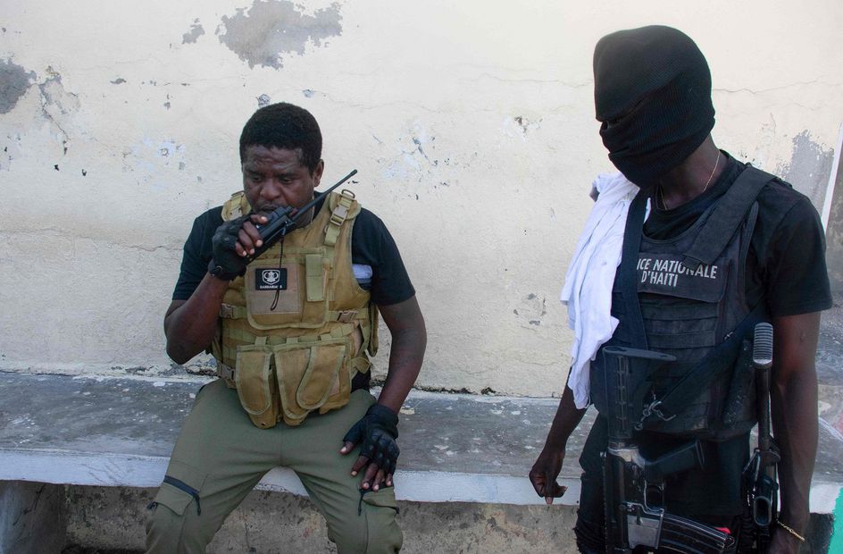 El  líder de la banda Jimmy "Barbecue" Cherizier habla por su walkie talkie antes de una misión, en Puerto Príncipe. Este hombre se presenta  como un revolucionario y rara vez se le ve sin su rifle y sus cargadores de munición de repuesto. NOTA: CLARESN SIFFROY. AFP