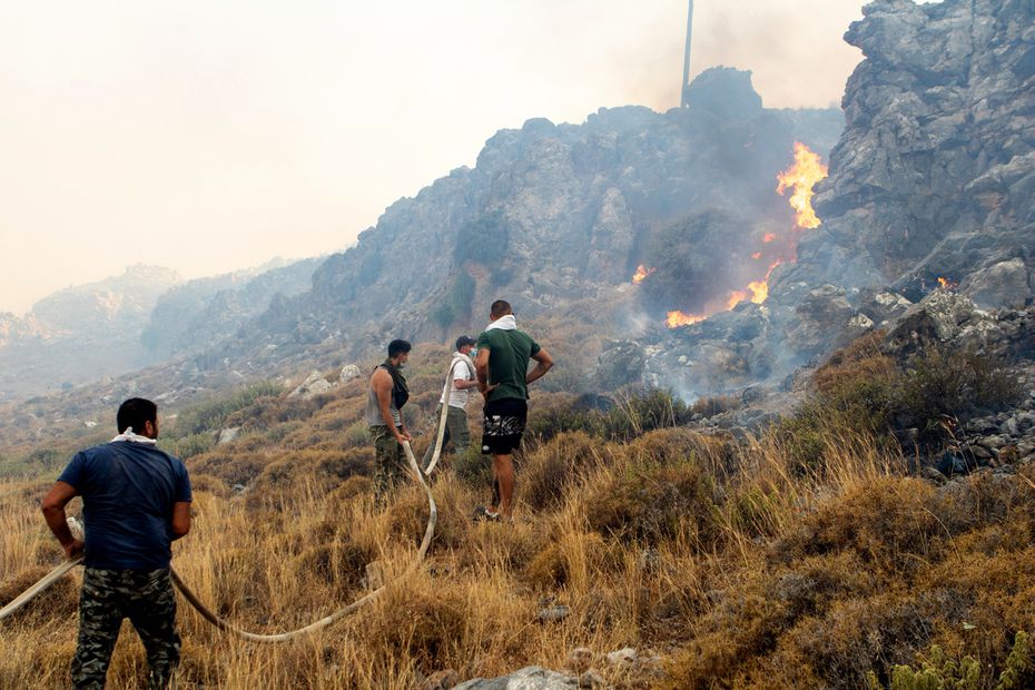 Voluntarios intentan apagar un incendio forestal en el pueblo de Kiotari, en la isla de Rodas. Foto: EFE