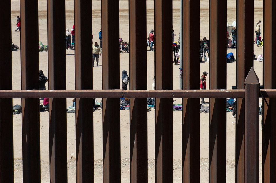 Una imagen aérea muestra a migrantes esperando a lo largo del muro fronterizo para entregarse a los agentes de la patrulla fronteriza de Aduanas y Protección Fronteriza (CBP) para procesar sus solicitudes de inmigración y asilo después de cruzar el río Grande hacia  Estados Unidos, el 11 de mayo de 2023. Foto: AFP