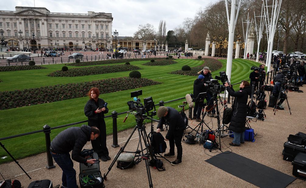 Los medios de comunicación se reúnen frente al Palacio de Buckingham en Londres. La Casa Real anunció que el rey Carlos III está siendo tratado por cáncer. Foto: EFE