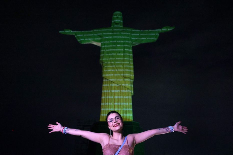 Fan posa frente a la imagen proyectada sobre el Cristo Redentor para dar la bienvenida a Taylor Swift en Río de Janeiro, Brasil. Foto: AFP
