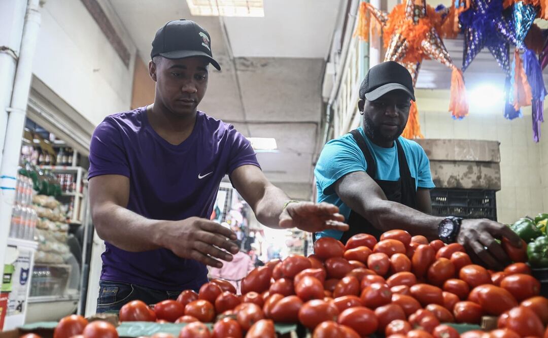 Dairon, de Cuba, y Francis,de República Dominicana, son dos migrantes que trabajan en el Mercado Nezahualcoyotl. Foto: Gabriel Pano El Universal