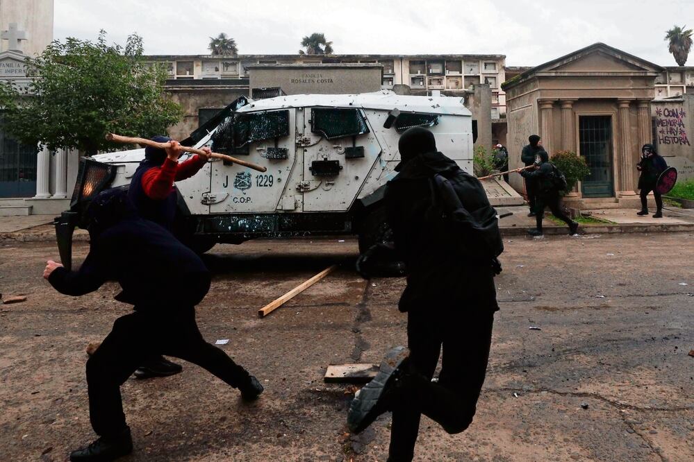 Manifestantes se enfrentan con la policía durante la marcha por las víctimas de la dictadura, en Santiago. Foto: Luis Hidalgo | AP