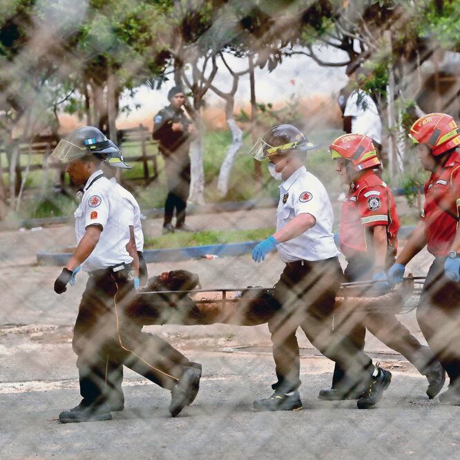 Violencia. Bomberos sacan a un recluso muerto, tras el motín, ayer en la G ranja de Rehabilitación Pavón. ESTEBAN BIBA. EFE