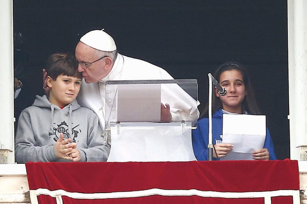 El papa Francisco celebró ayer el rezo del Ángelus acompañado por dos niños italianos, que participaron en la Caravana de la Paz 2016, un evento organizado por Acción Católica de Roma (TONY GENTILE. REUTERS)