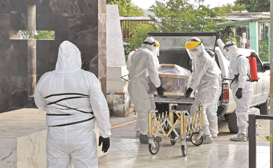 Los sepultureros son los últimos que manipulan los ataúdes, los cargan y los conducen al yoo’ ba’ (la casa de los muertos); los familiares observan a lo lejos. Fotos: ROSELIA CHACA. EL UNIVERSAL