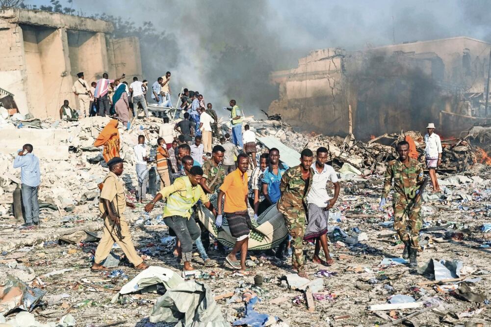 Civiles y soldados somalíes trataron de rescatar a víctimas de la explosión de un camión bomba en Mogadiscio. (MOHAMED ABDIWAHAB. AFP)