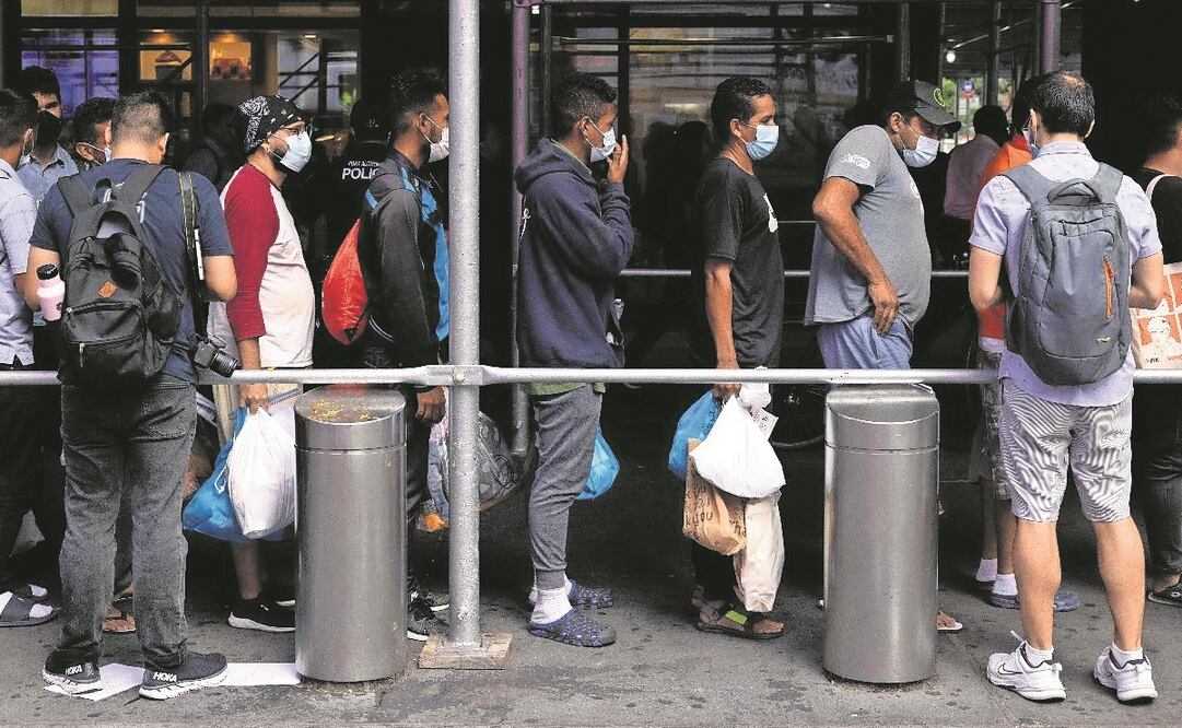 Un grupo de migrantes, frente a la Terminal de Autobuses de la Autoridad Portuaria espera recibir asistencia humanitaria, en Nueva York. 