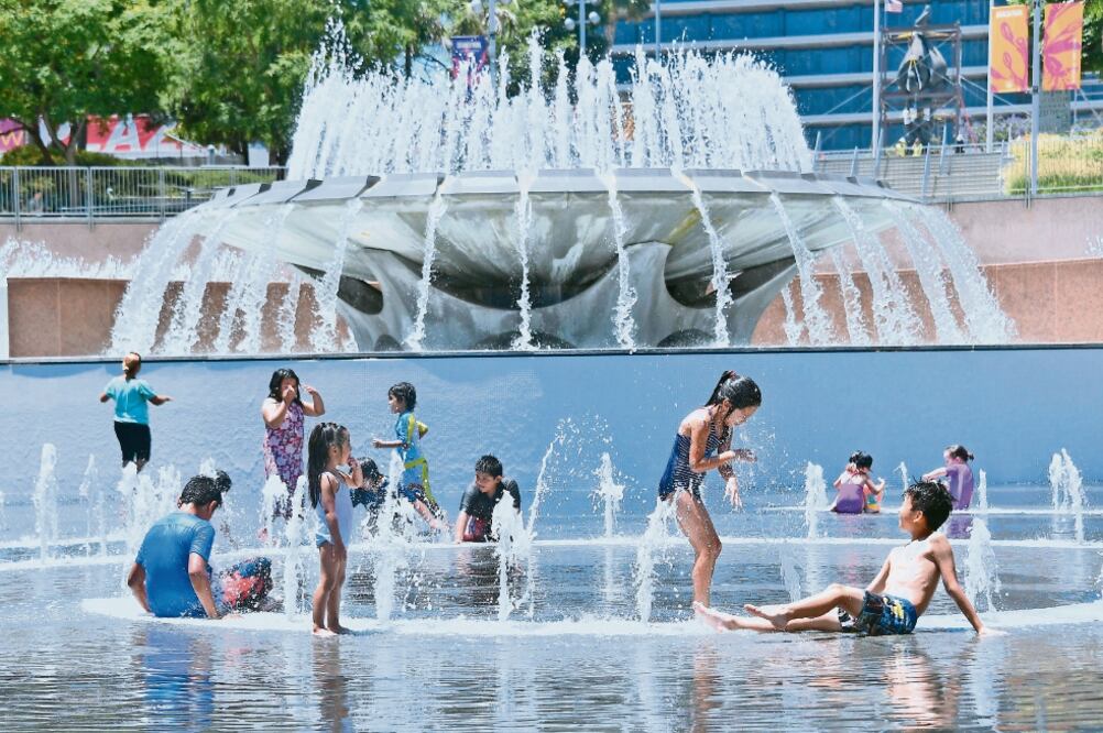 Alivio. Niños se refrescan en una fuente en Los Ángeles, afectada por una ola de calor. (FREDERIC J. BROWN. AFP)