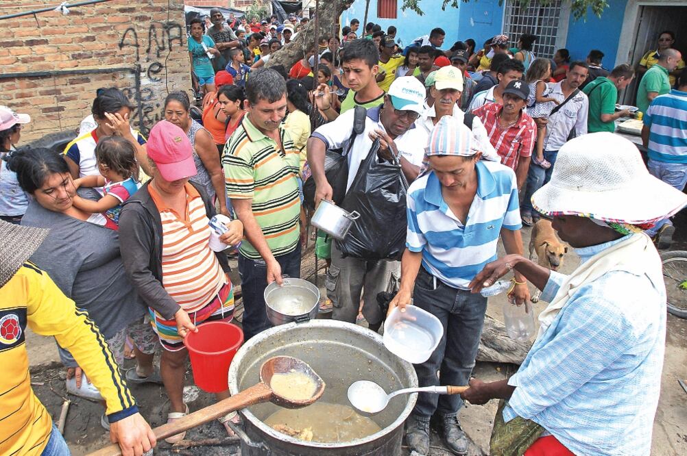 Colombianos ofrecen un almuerzo colectivo a los deportados o retornados de Venezuela en el patio de una de las viviendas del sector de La Parada, cerca de Cúcuta (MAURICIO DUEÑAS CASTAÑEDA. EFE)