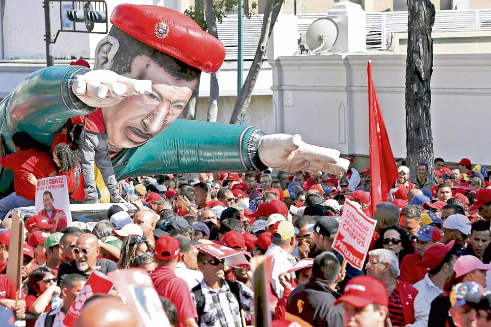 Empleados de PDVSA marchan con una figura inflable del fallecido presidente Hugo Chávez, en un mitin, ayer, en Caracas (CARLOS GARCÍA RAWLINS. REUTERS)