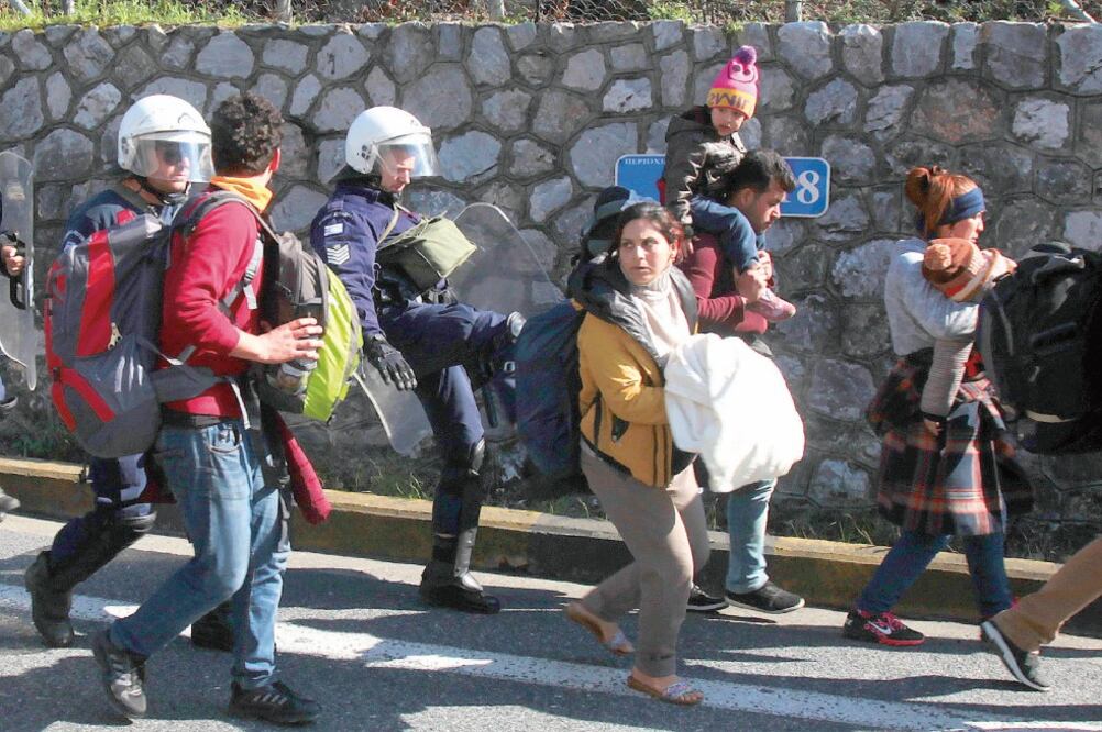 Un policía patea a una migrante durante una protesta cerca de la ciudad de Larissa, Grecia, donde miles esperan a que los países aledaños reabran sus fronteras (GIORGOS KYDONAS. AP)