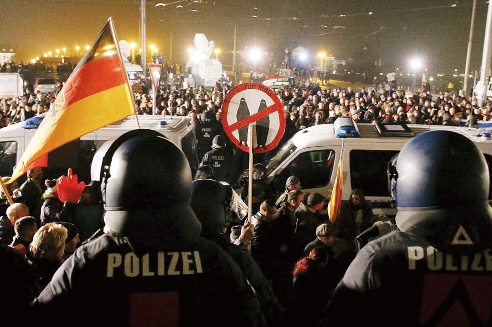 La policía alemana resguarda la seguridad durante la manifestación convocada por el movimiento islamófobo Pegida ayer, en Dresde, donde se dieron cita alrededor de 20 mil simpatizantes (FABRIZIO BENSCH. REUTERS)