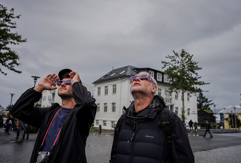 La gente usa sus lentes especiales para poder observar el eclipse solar, en Reikiavik, Islandia. FOTO: MARCO DI MARCO. AP