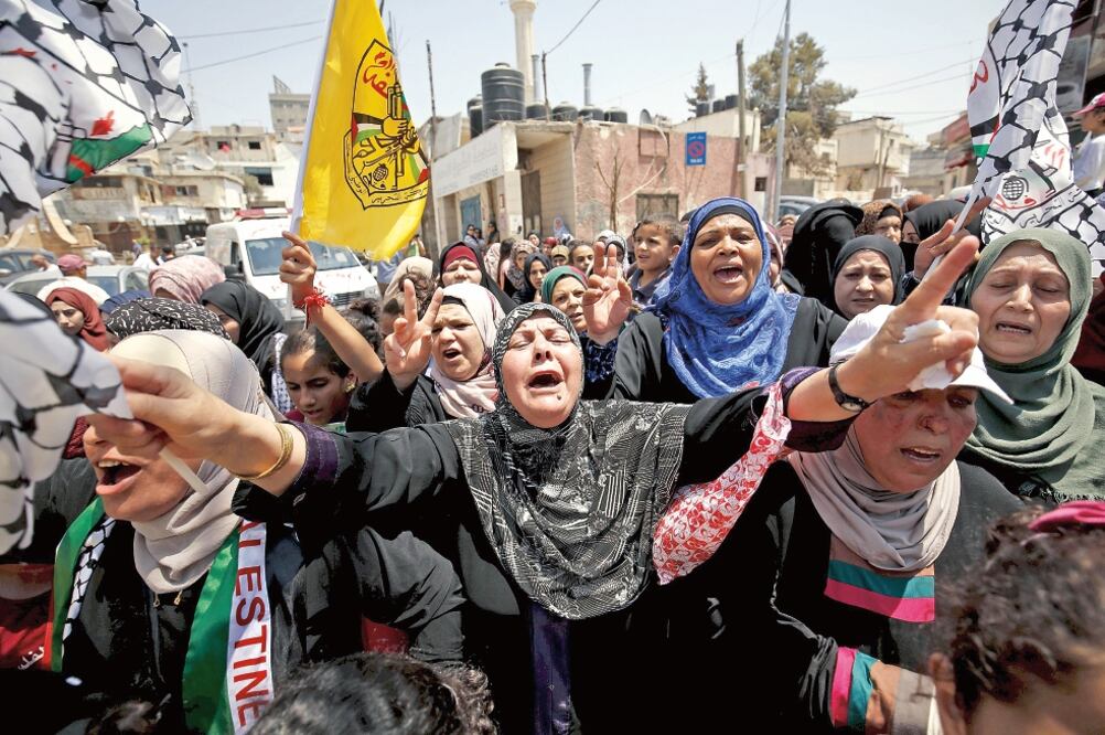 Mujeres palestinas gritan consignas en Ramalá durante el funeral del joven palestino Laith Khamdi (MOHAMAD TOROKMAN. REUTERS)