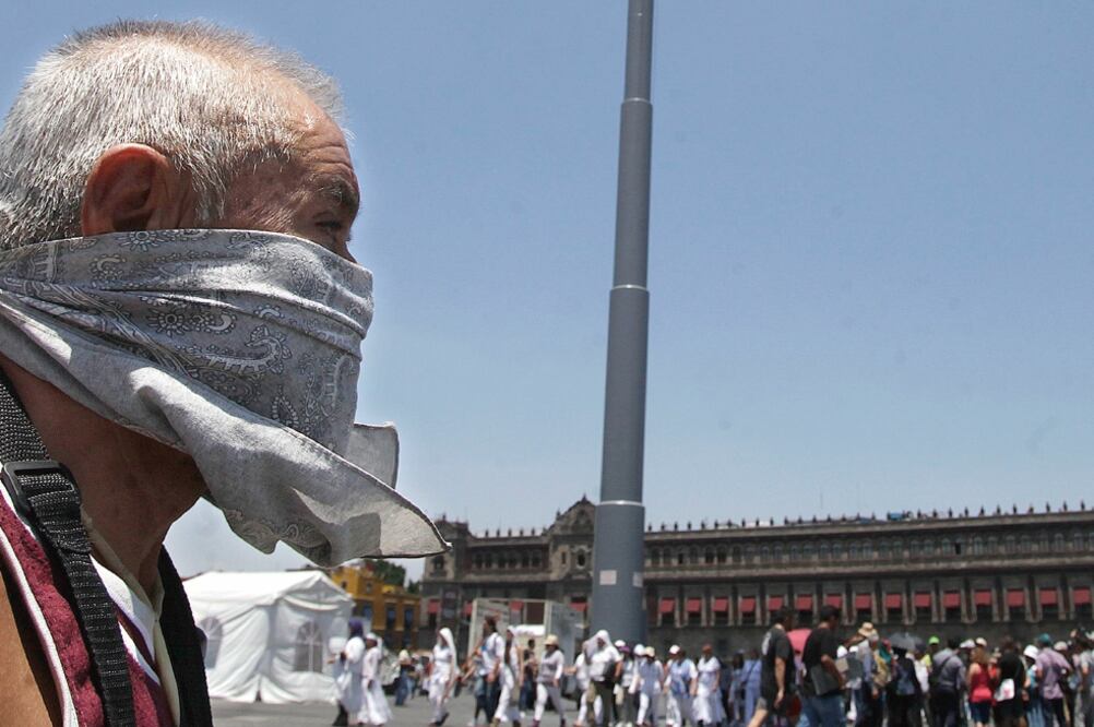 Un trabajador proveniente del estado de Hidalgo se cubre el rostro para evitar respirar el smog de la ciudad (JUAN CARLOS REYES. EL UNIVERSAL)
