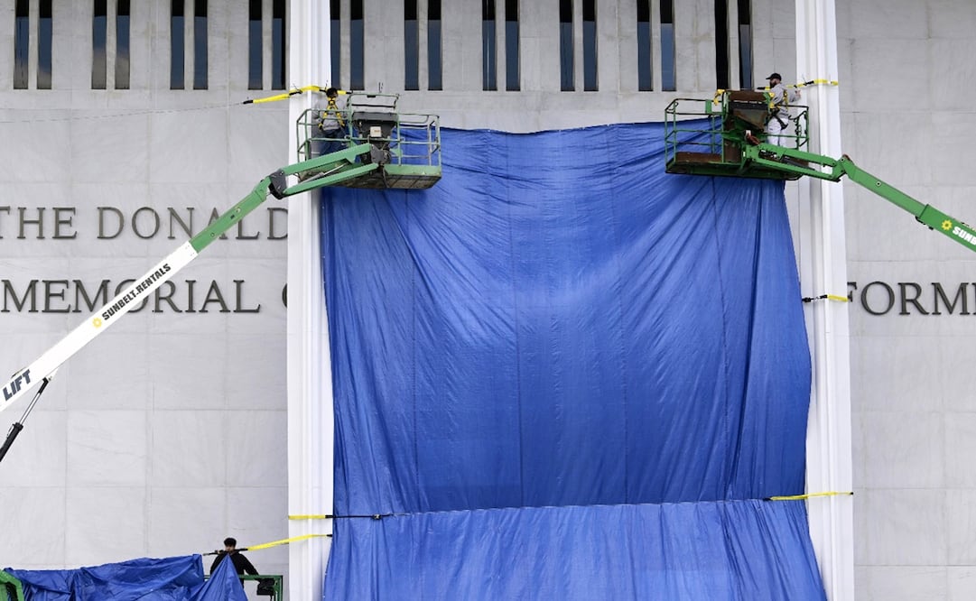 Dos personas descubren la fachada del Centro Kennedy de las Artes Escénicas en el que se lee el nombre de 'The Donald J. Trump' . Foto: EFE/ Lenin Nolly.