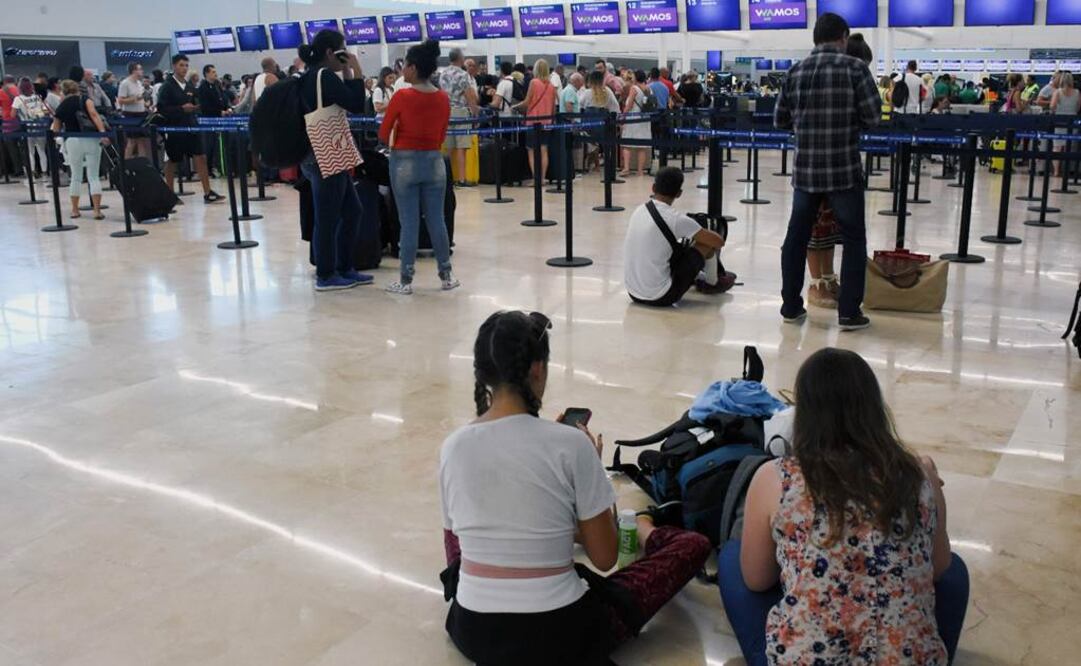 Pasajeros varados esperan cerca del mostrador cerrado de Thomas Cook en el Aeropuerto Internacional de Cancún, México. (Photo by ELIZABETH RUIZ / AFP)