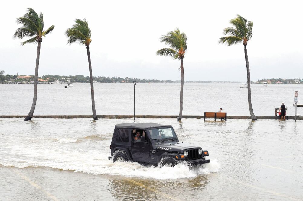 Un vehículo transita por un terreno inundado, antes de la posible llegada del huracán Dorian, en Palm Beach, Florida. Hasta un millón de personas han recibido peticiones u órdenes de evacuación. Foto/JIM RASSOL. EFE