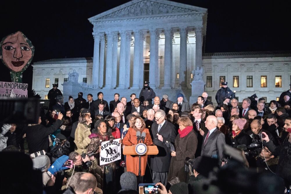 El líder del Senado de Estados Unidos, Chuck Schumer (centro a la derecha); la líder de la minoría de la Cámara de Representantes, Nancy Pelosi (centro), e integrantes del Congreso participaron ayer en una protesta contra el veto migratorio. (SHAWN THEW.)