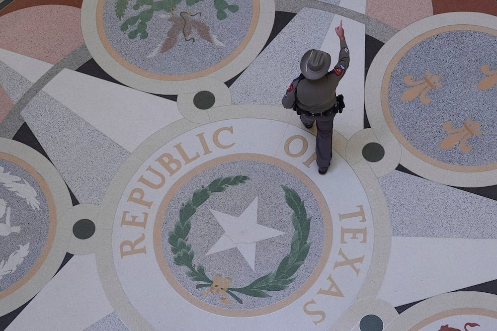 Un agente de la policía de Texas pasa por encima del escudo del estado en el Capitolio, antes de un debate sobre la redistribución del mapa electoral en una sesión especial del Senado, en Austin, Texas, el 22 de agosto pasado. Foto: AP