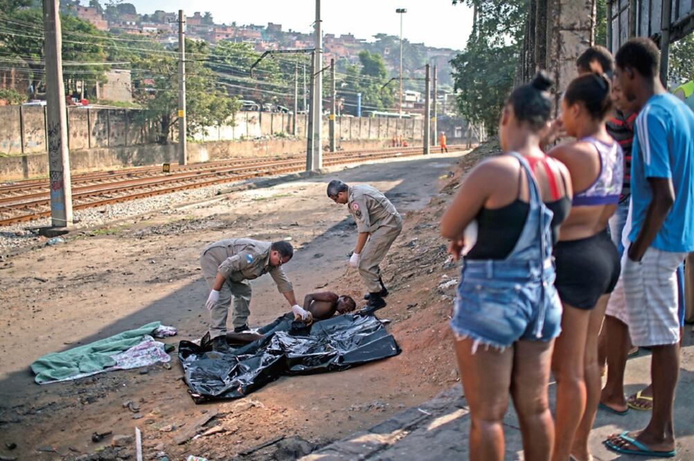 Autoridades revisan el cuerpo de un joven negro asesinado en Río de Janeiro, en junio pasado (ARCHIVO. AP)