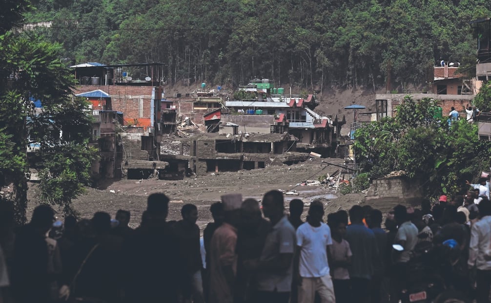 Residentes observan edificios sepultados por el barro tras unas inundaciones repentinas y un desprendimiento de tierra en Devghat, en el distrito nepalí de Nuwakot. Foto: AFP