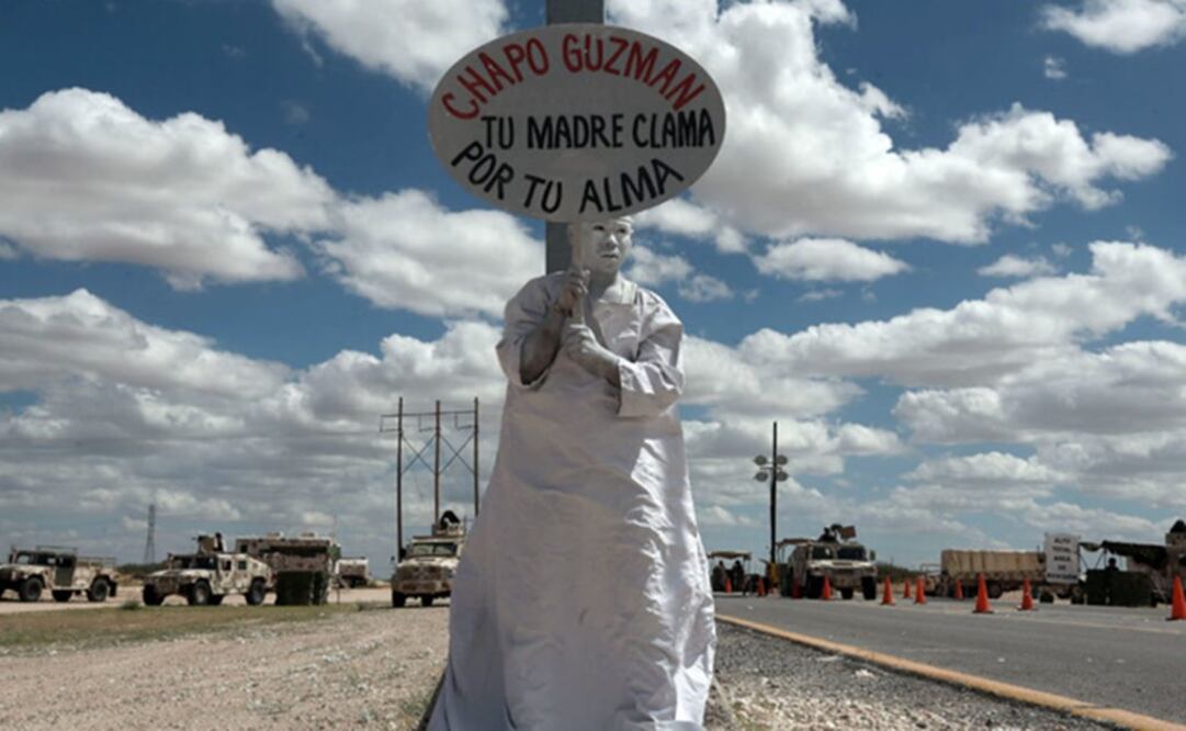 A member of an evangelical organization holds a sign with a message reading "Chapo Guzmán, your mother prays for your soul" Photo: AP/Christian Torres