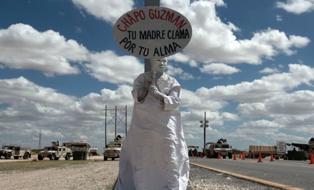 A member of an evangelical organization holds a sign with a message reading "Chapo Guzmán, your mother prays for your soul" Photo: AP/Christian Torres