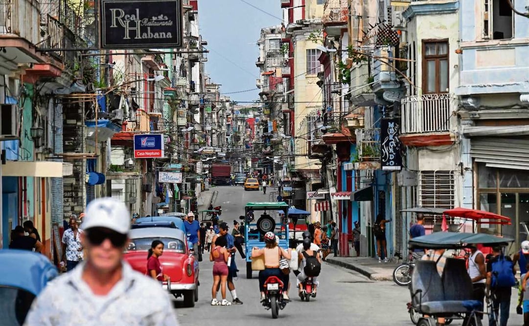 Cubanos y turistas, en una concurrida calle bordeada de edificios en La Habana, el 5 de junio pasado. Foto: YAMIL LAGE / AFP