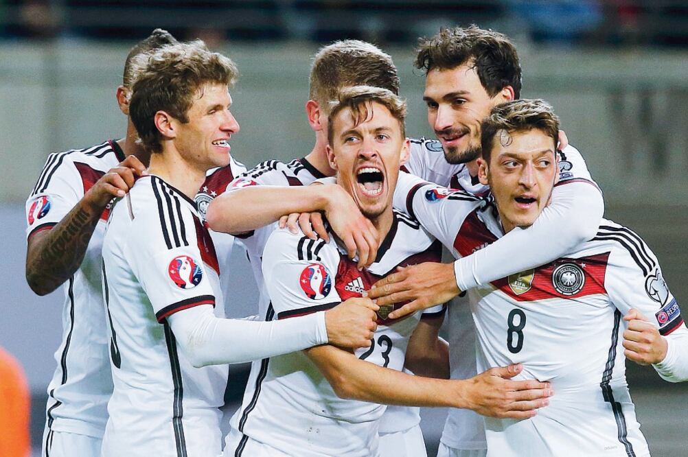 Max Kruse (23) es felicitado por sus compañeros germanos tras marcar el gol de la calificación a la Eurocopa (FABRIZIO BENSCH. REUTERS)