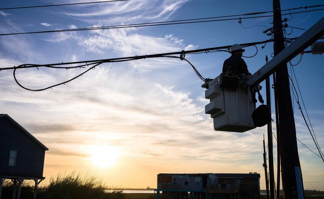 Un trabajador de servicios públicos trabaja para restaurar una línea eléctrica dañada después de que el huracán Beryl. Foto: AFP