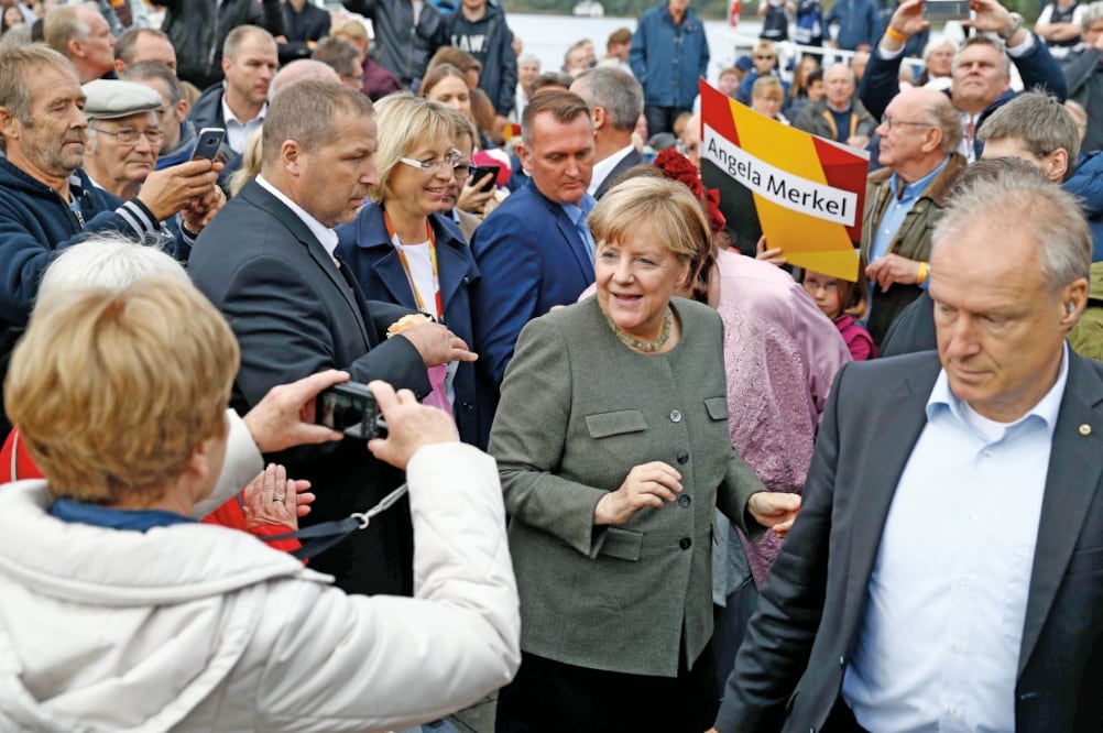 La canciller Angela Merkel es fotografiada con simpatizantes durante un evento de campaña de la Unión Demócrata Cristiana el pasado 20 de septiembre en Kappeln, Alemania. (ODD ANDERSEN. AFP)