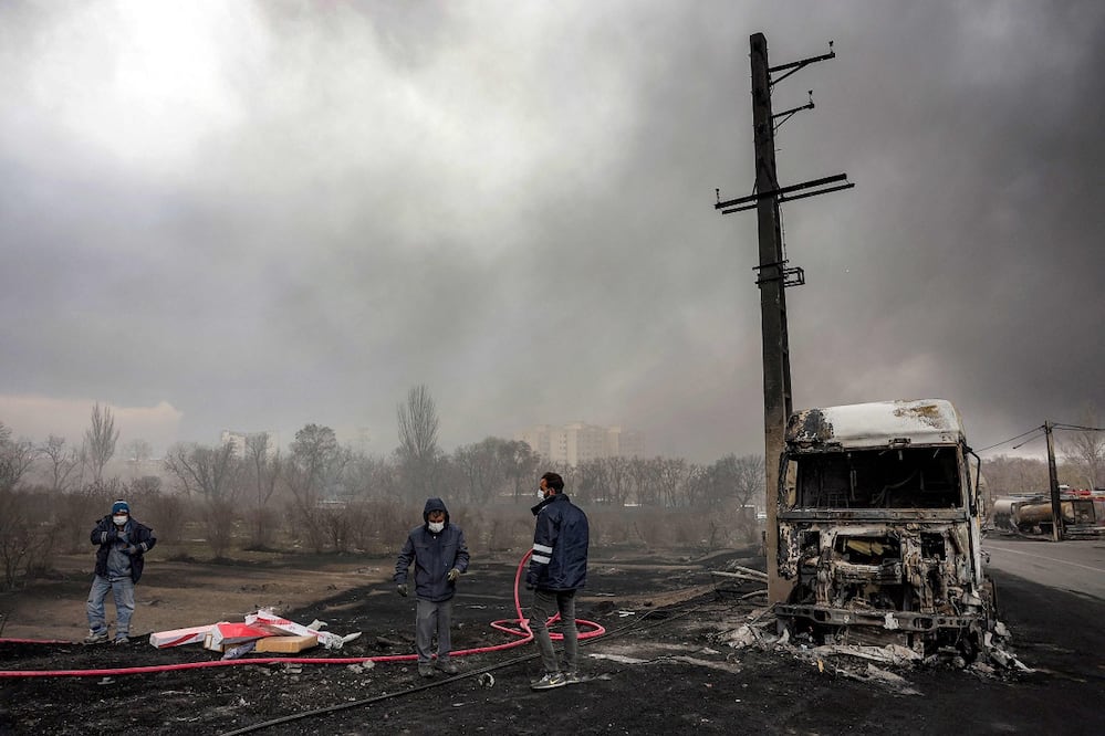 Un elemento de la defensa civil iraní observa la nube tóxica que han dejado en Teherán los ataques israelíes contra depósitos de combustible. FOTO: AFP