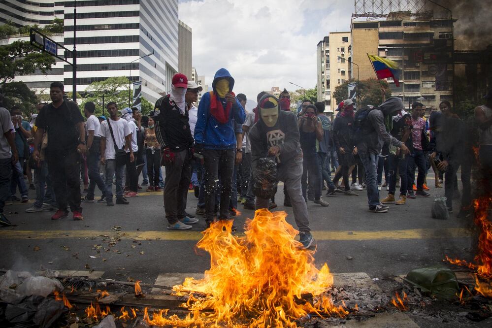 Manifestantes participan en un enfrentamiento con miembros de las fuerzas de seguridad durante una protesta de la oposición en la ciudad de Caracas. (Foto: XINHUA)