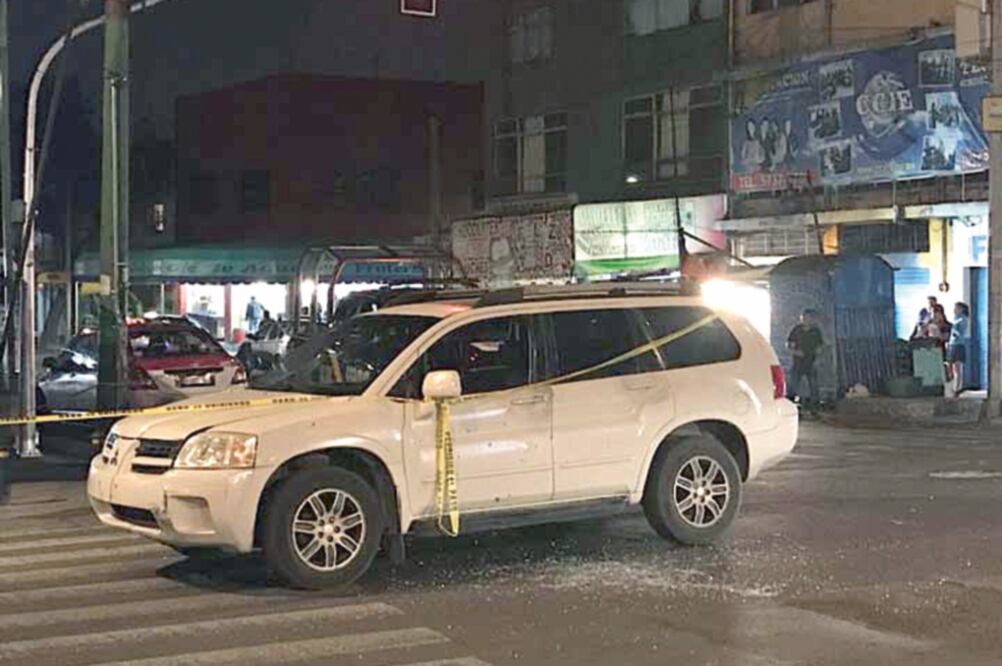 La camioneta donde atacaron a la pareja quedó sobre avenida Eduardo Molina casi esquina con Calle 310, donde policías la resguardaron de curiosos. (ESPECIAL)