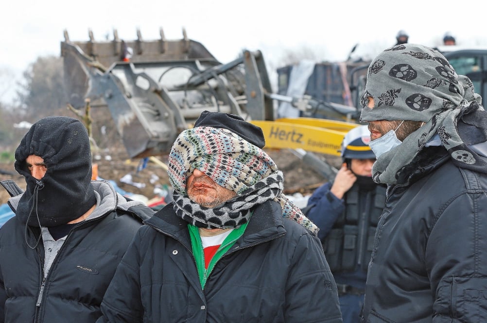 Migrantes iraníes, con los labios cosidos, protestaron ayer contra el desmantelamiento parcial en el campamento para refugiados de Calais, conocido como “la jungla” (YVES HERMAN)